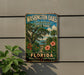 A vintage-style metal sign for Washington Oaks Gardens State Park in Florida, featuring a tropical landscape with palm trees, flowers, and a beach.