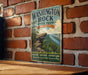 A vintage metal sign for Washington Rock State Park in New Jersey, featuring a scenic image of a rocky cliff overlooking a river.