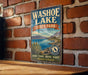 A vintage-style metal sign for Washoe Lake State Park in Nevada, featuring a scenic landscape with mountains, a lake, and various outdoor activities such as hiking, fishing, and wildlife watching.