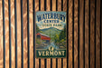 A vintage metal sign for Waterbury Center State Park in Vermont, featuring a red barn and a scenic mountain landscape.