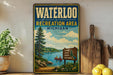 A vintage-style metal sign for the Waterloo Recreation Area in Michigan, featuring a scenic landscape with a lake, pine trees, and people enjoying outdoor activities.