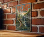 A vintage metal sign for Watkins Glen State Park in New York, featuring a scenic waterfall and hiking trails.