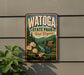 A vintage-style metal sign for Watoga State Park in West Virginia, featuring a scenic landscape with a river, pine trees, and a wooden cabin.
