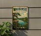 A vintage-style metal sign for Waubonsie State Park in Iowa, featuring a scenic landscape with a river, trees, and a cliff.