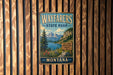 A vintage metal sign for Wayfarers State Park in Montana, featuring a scenic mountain landscape and a welcoming message.