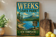 A vintage-style metal sign for Weeks State Park in New Hampshire, featuring a scenic landscape with a lake, mountains, and pine trees.