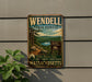 A vintage metal sign for Wendell State Forest in Massachusetts, featuring a scenic landscape with pine trees, a lake, and mountains.