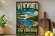 A vintage-style poster advertising Wentworth State Park in New Hampshire, featuring a scenic landscape with a lake, mountains, and pine trees.