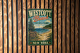 A vintage-style metal sign for Westcott Beach State Park in New York, featuring a scenic landscape with a beach, pine trees, and a lake.
