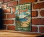 A vintage-style metal sign for Westcott Beach State Park in New York, featuring a scenic beach landscape with a pine tree and a sign indicating the park's location.