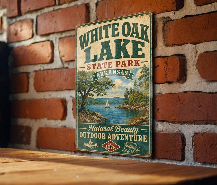 A vintage-style metal sign for White Oak Lake State Park in Arkansas, featuring a scenic landscape with a lake, mountains, and a sailboat.