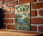 A vintage-style metal sign for White Oak Lake State Park in Arkansas, featuring a scenic landscape with a lake, mountains, and a sailboat.