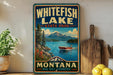 A vintage-style sign for Whitefish Lake State Park in Montana, featuring a scenic image of a lake surrounded by mountains and a boat on the water.