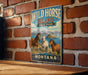 A vintage metal sign for Wild Horse Island State Park in Montana, featuring illustrations of three horses in a scenic landscape.