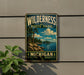 A vintage-style metal sign for Wilderness State Park in Michigan, featuring a scenic landscape with pine trees, a lake, and mountains.