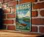A vintage-style metal sign for Wilkus State Park in Vermont, featuring a scenic image of a lake with a canoe, mounted on a brick wall.