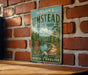 A vintage-style metal sign for William B.UMSTead State Park, featuring a scenic illustration of a forest and a river, mounted on a brick wall.
