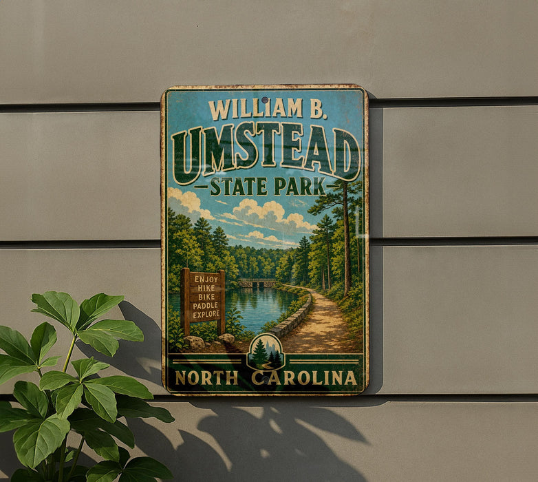 A vintage-style metal sign for William B. Umstead State Park in North Carolina, featuring a scenic landscape with a river and forest.