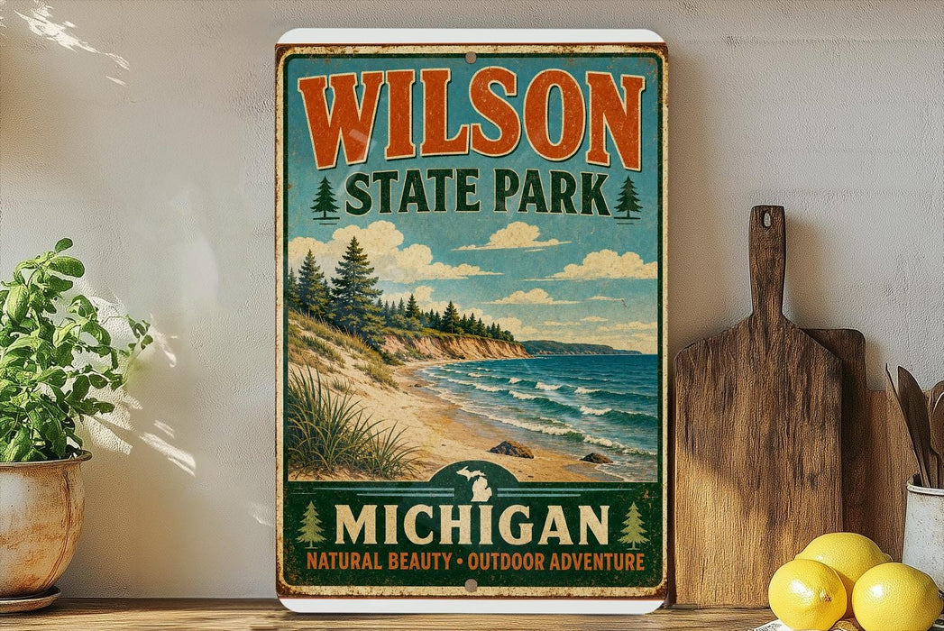 A vintage-style metal sign for Wilson State Park in Michigan, featuring a scenic landscape with pine trees, a beach, and a lake.