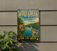 A vintage-style metal sign for Wolf Creek State Park in Illinois, featuring a wolf standing on a rock overlooking a river.