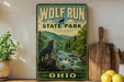 A vintage-style sign for Wolf Run State Park in Ohio, featuring a wolf silhouette and a scenic mountain landscape.