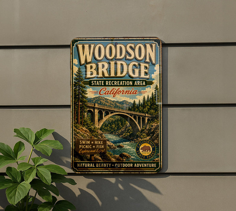 A vintage-style metal sign for the Woodson Bridge, a state recreation area in California, featuring a scenic illustration of the bridge and surrounding landscape.