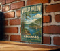 A vintage-style sign for Wolly Hollow State Park in Arkansas, featuring a scenic landscape with a lake, mountains, and a sailboat.