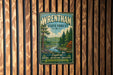 A vintage metal sign for Wrentham State Forest, featuring a scenic illustration of a forest landscape with a river and pine trees.