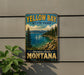 A vintage-style metal sign for Yellow Bay State Park, featuring a scenic landscape with a lake, mountains, and pine trees.
