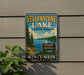 A vintage-style sign for Yellowstone Lake State Park in Wisconsin, featuring a scenic image of the lake surrounded by pine trees and mountains.