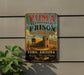 A vintage-style sign for Yuma Territorial Prison, featuring a desert landscape with a castle-like structure, is displayed on a wall.