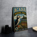 A vintage metal sign for the Acadia Birding Trail in Maine, featuring a puffin bird and various trail descriptions.