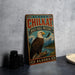 A vintage-style metal sign with the text "ALASKA CHILKAT BALD EAGLE PRESERVE" and an illustration of an eagle perched on a tree branch, set against a backdrop of mountains and a river.
