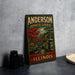 A vintage metal sign for Anderson Japanese Gardens in Illinois, featuring a scenic illustration of a Japanese garden with a bridge and pagoda.