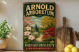 A vintage-style sign for the Arnold Arboretum of Harvard University in Massachusetts, featuring a colorful illustration of a garden with flowers and trees.