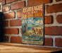 A vintage metal sign for Assateague Island Birding Area in Maryland, featuring illustrations of birds and a lighthouse, mounted on a brick wall.