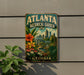 A vintage-style metal sign for the Atlanta Botanical Garden in Georgia, featuring a colorful illustration of the garden and the city skyline.