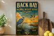a vintage-style sign for the National Wildlife Refuge in Virginia, with a scenic illustration of a bird and a sunset in the background.