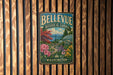 A vintage-style metal sign for the Bellevue Botanical Garden in Washington, featuring a colorful illustration of a greenhouse surrounded by flowers and trees.