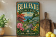 A vintage-style metal sign for the Bellevue Botanical Garden in Washington, featuring a colorful illustration of a garden with flowers, trees, and a greenhouse.