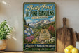 A vintage-style metal sign advertising Betty Ford Alpine Gardens in Colorado, featuring a mountain landscape with flowers and a wooden cutting board.