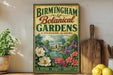 A vintage-style sign for the Birmingham Botanical Gardens in Birmingham, Alabama, featuring a garden scene with a greenhouse and flowers.