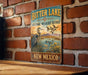 A vintage metal sign for the Bitter Lake National Wildlife Refuge in New Mexico, featuring an illustration of a heron and ducks in a lake.