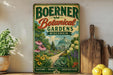 A vintage-style metal sign for Boerner Botanical Gardens in Wisconsin, featuring a lush garden scene with flowers, plants, and a greenhouse.