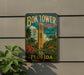A vintage-style sign for the Bok Tower Gardens in Florida, featuring a tropical landscape with palm trees, flowers, and a large tower.