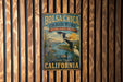 A vintage-style metal sign for the Bolsa Chica Ecological Reserve, featuring illustrations of various birds and wildlife, is displayed on a wooden wall.