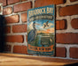 A vintage-style metal sign for the Braddock Bay Bird Observatory, featuring a large blue heron and the text "Discover, Protect, Educate" along with the location "Hilton, New York".
