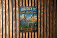 A vintage metal sign for the Braddock Bay Bird Observatory, featuring a blue heron and a bird in flight, mounted on a wooden wall.