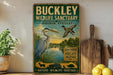 A vintage-style sign for the Buckley Wildlife Sanctuary in Audubon, Kentucky, featuring illustrations of a heron and ducks in a natural setting.