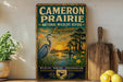 a vintage-style sign for Cameron Prairie National Wildlife Refuge in Louisiana, with a serene landscape depicting a heron and a sunset over a body of water.